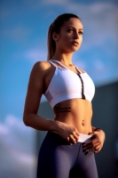 Eine weibliches Fitness Model mit eine blauen Fitness-Leggings und einen weißen Sport-BH